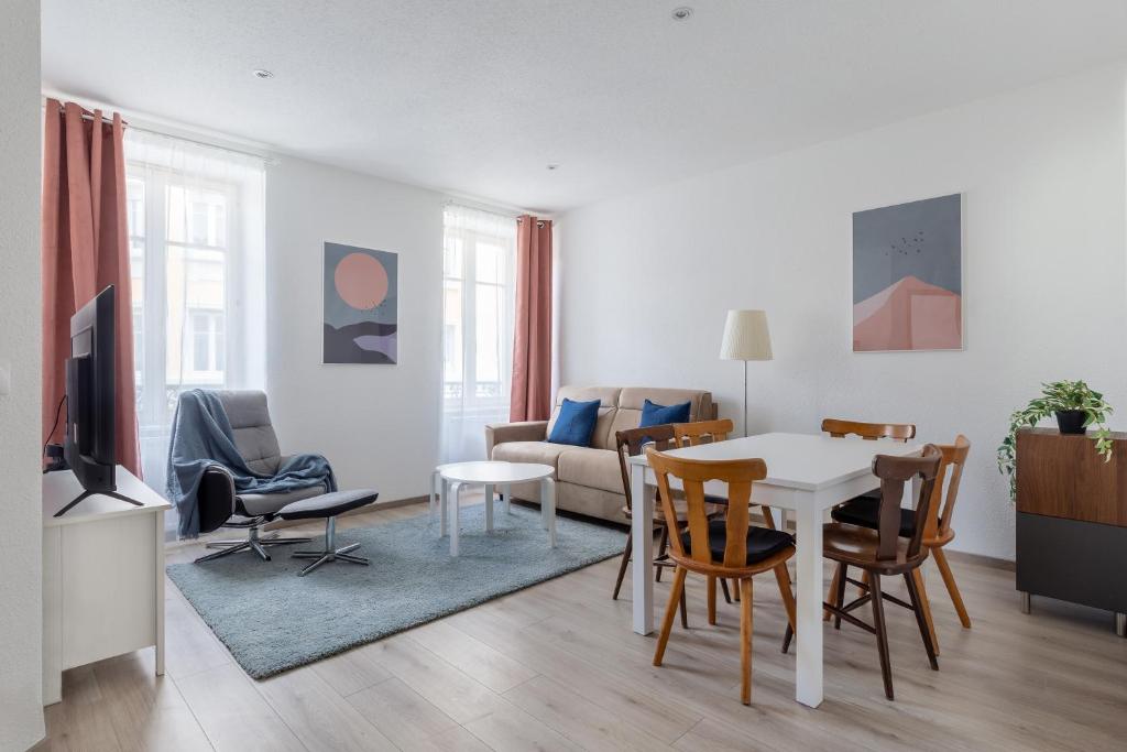 a living room with a table and chairs at Travel Homes - Niffel 2 - Un havre de paix près du Parc in Mulhouse