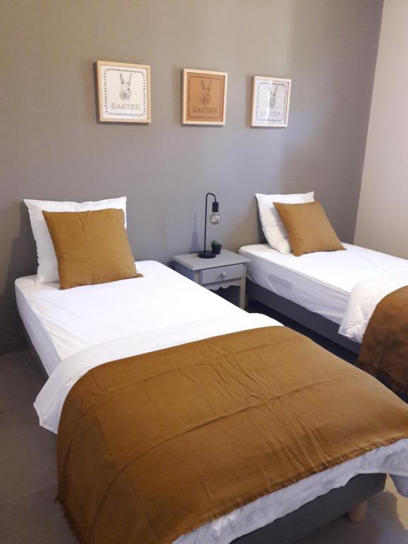 twee bedden naast elkaar in een kamer bij Maison climatisée avec piscine privée, 6 personnes in Aiguèze