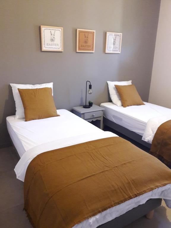 two beds sitting next to each other in a room at Maison climatisée avec piscine privée, 6 personnes in Aiguèze