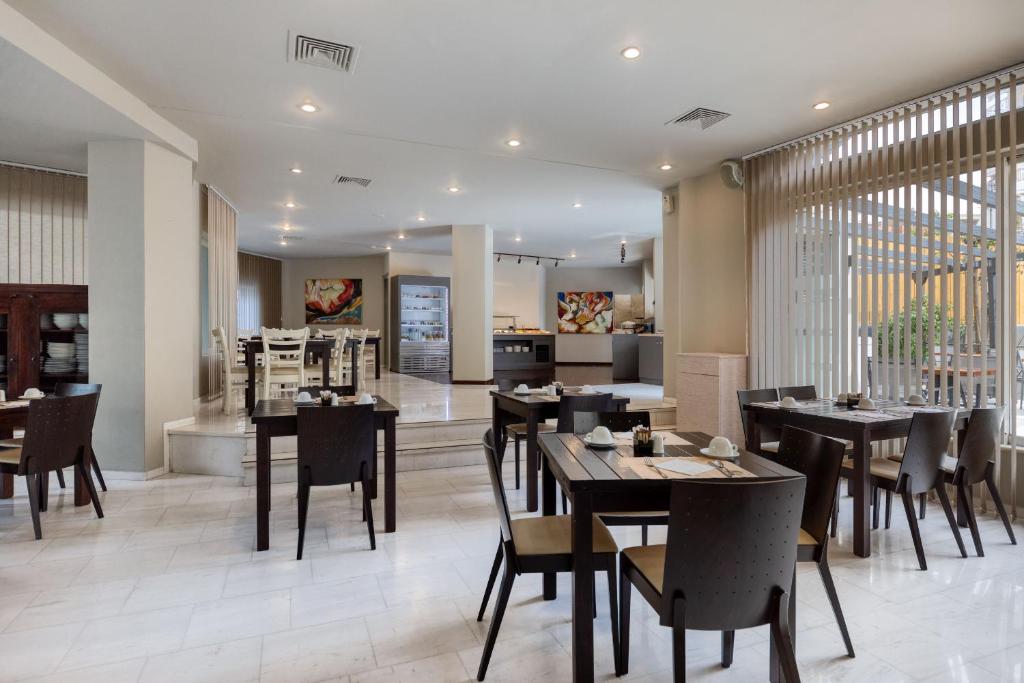 une salle à manger avec des tables et des chaises dans un restaurant dans l'établissement Hotel Nafpaktos, à Naupacte
