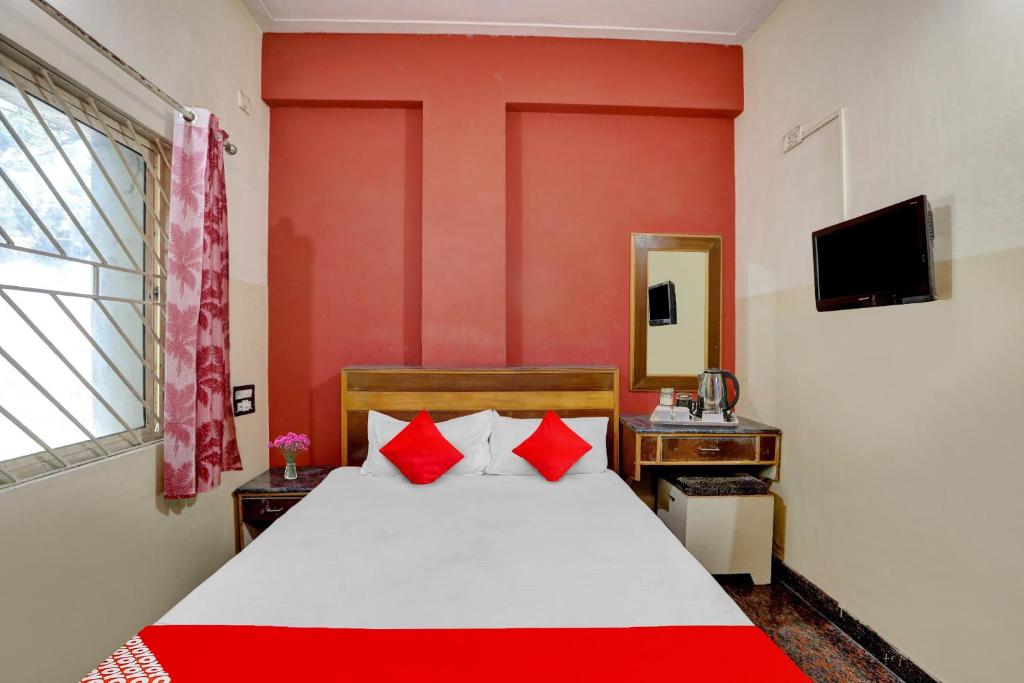 1 dormitorio con 1 cama grande y paredes rojas en OYO Hotel Sahara Residency, en Narasimharaja Puram