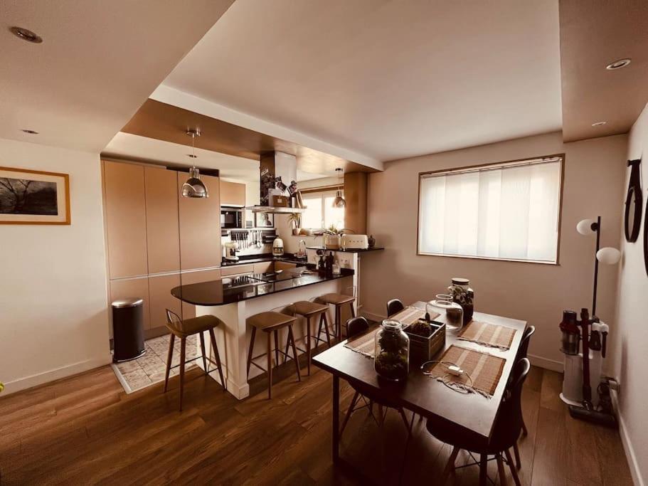 une cuisine avec une table et des chaises dans une pièce dans l'établissement Appartement proche de Paris, à Sartrouville