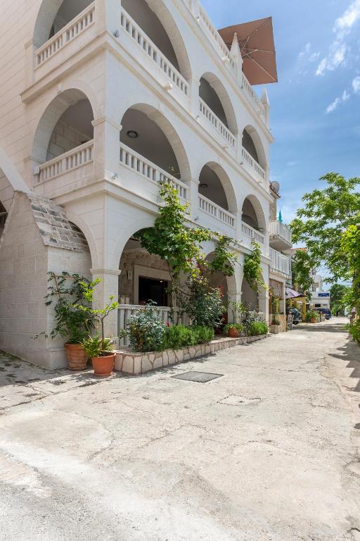 a large white building with arches and plants on it at Villa Stonehouse 2 in Milna