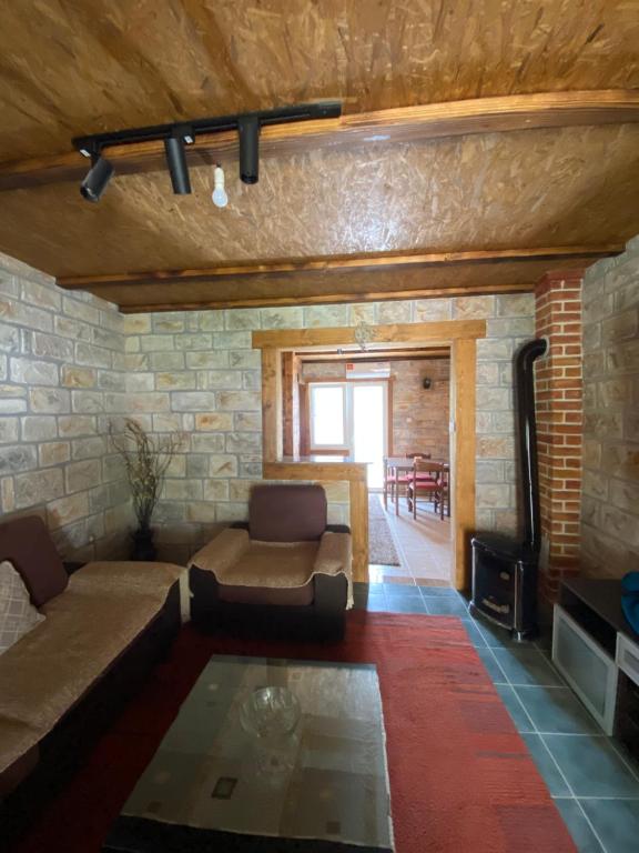 a living room with a couch and a stone wall at Skadar Lake Apartment Nikola I in Virpazar