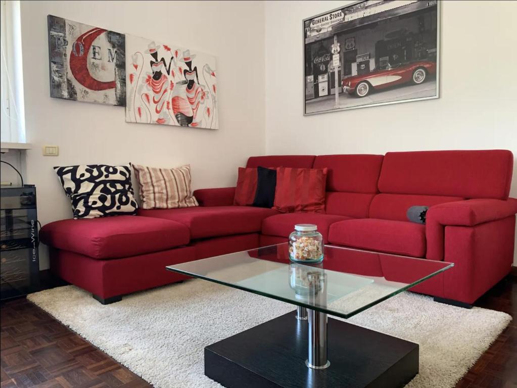 a living room with a red couch and a glass table at Bixio Lake View by Quokka 360 - Close to Como downtown in Como