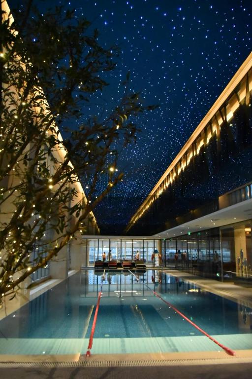 成都成都仁恒格蓝柏薇酒店公寓的夜晚带有游泳池的建筑物