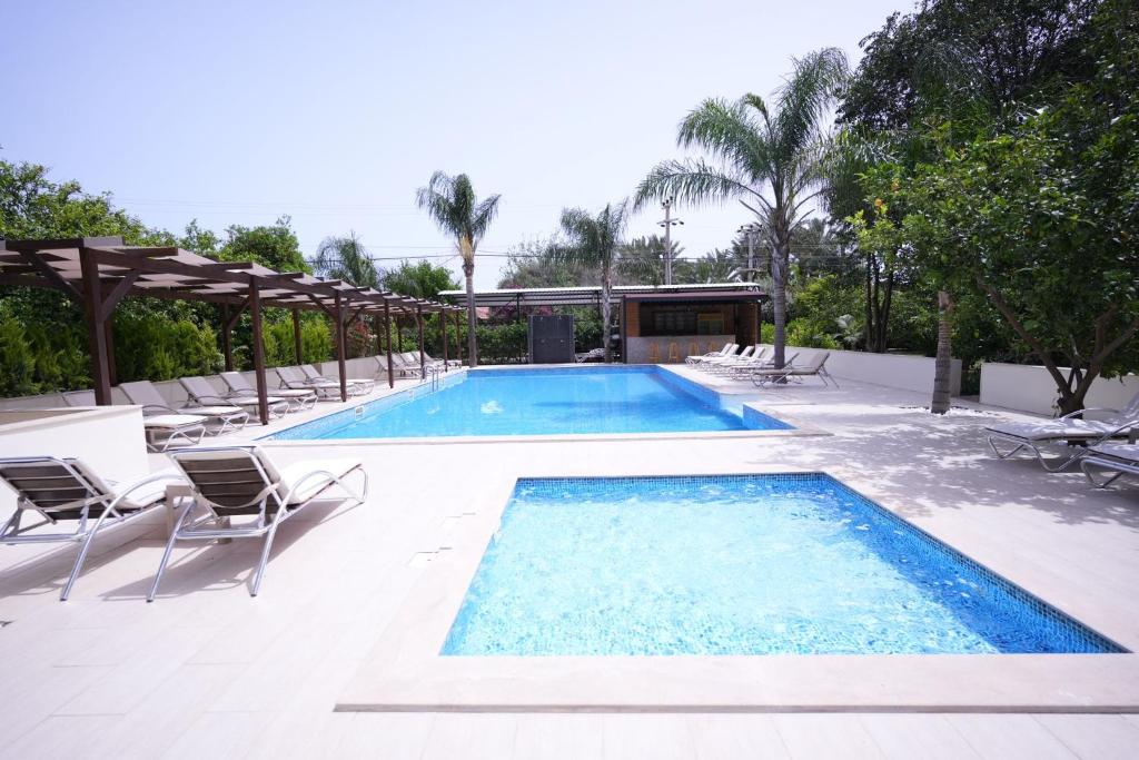 a large swimming pool with chairs and a table at Cirali Hotel in Cıralı