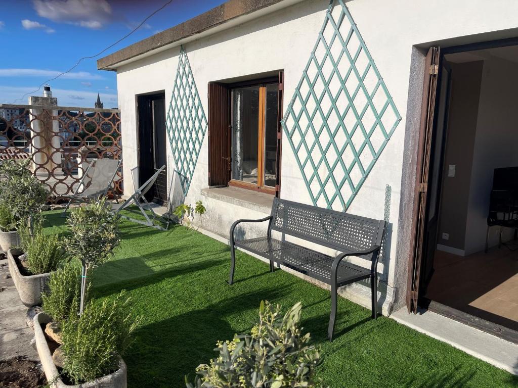 d'une terrasse avec un banc sur une pelouse. dans l'établissement Chez Malé - Joli appartement cosy avec grande terrasse et parking proche Parc Jourdan & Centre ville historique, à Aix-en-Provence