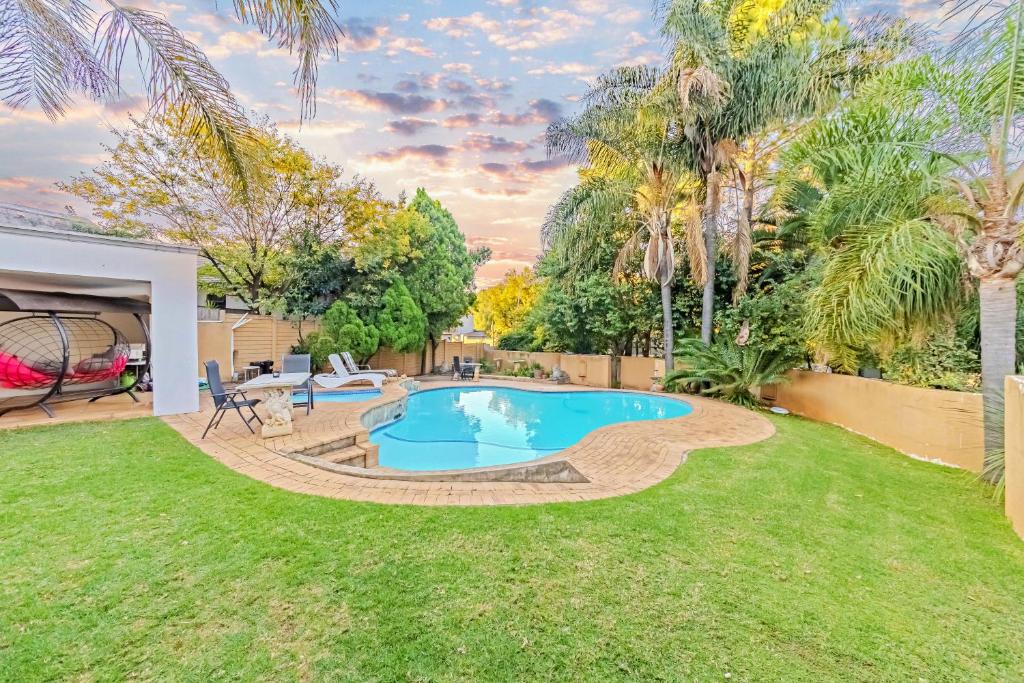 a backyard with a swimming pool and grass at Homely Haven in Roodepoort