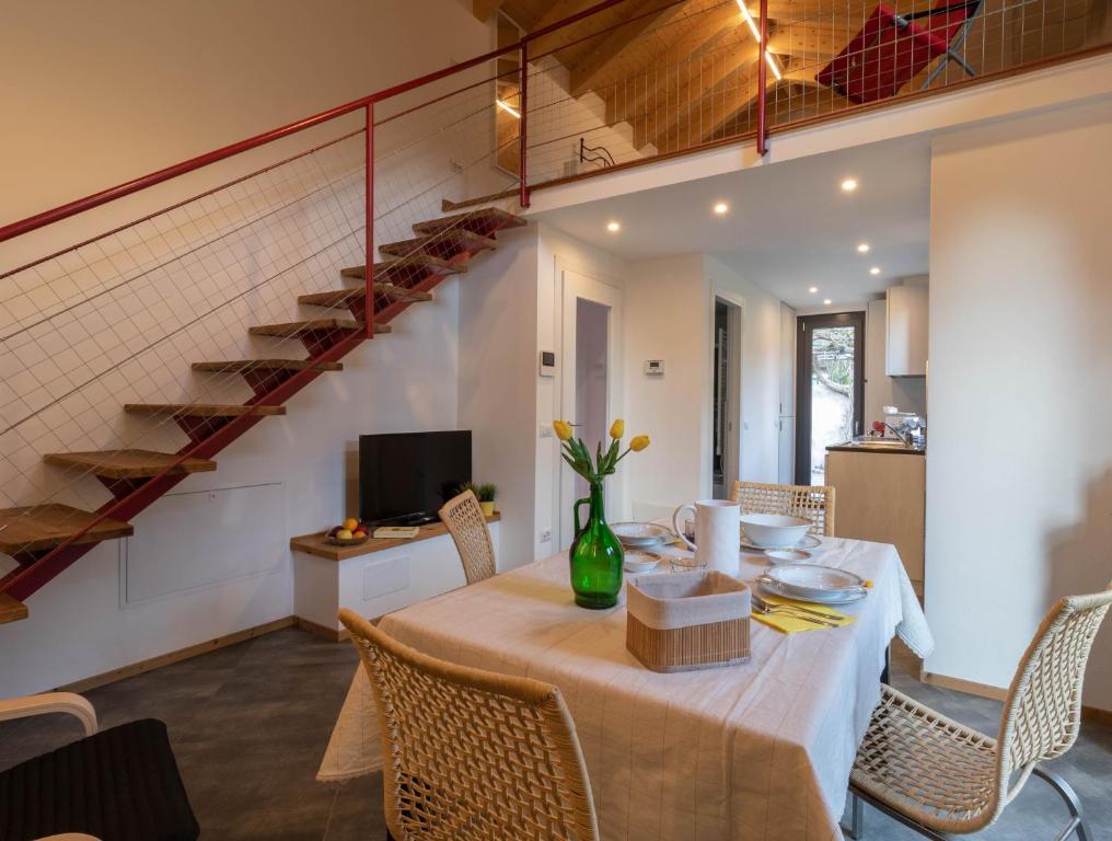 un comedor con una mesa con sillas y una escalera en Welcomely - Al Sollievo House en Lecco