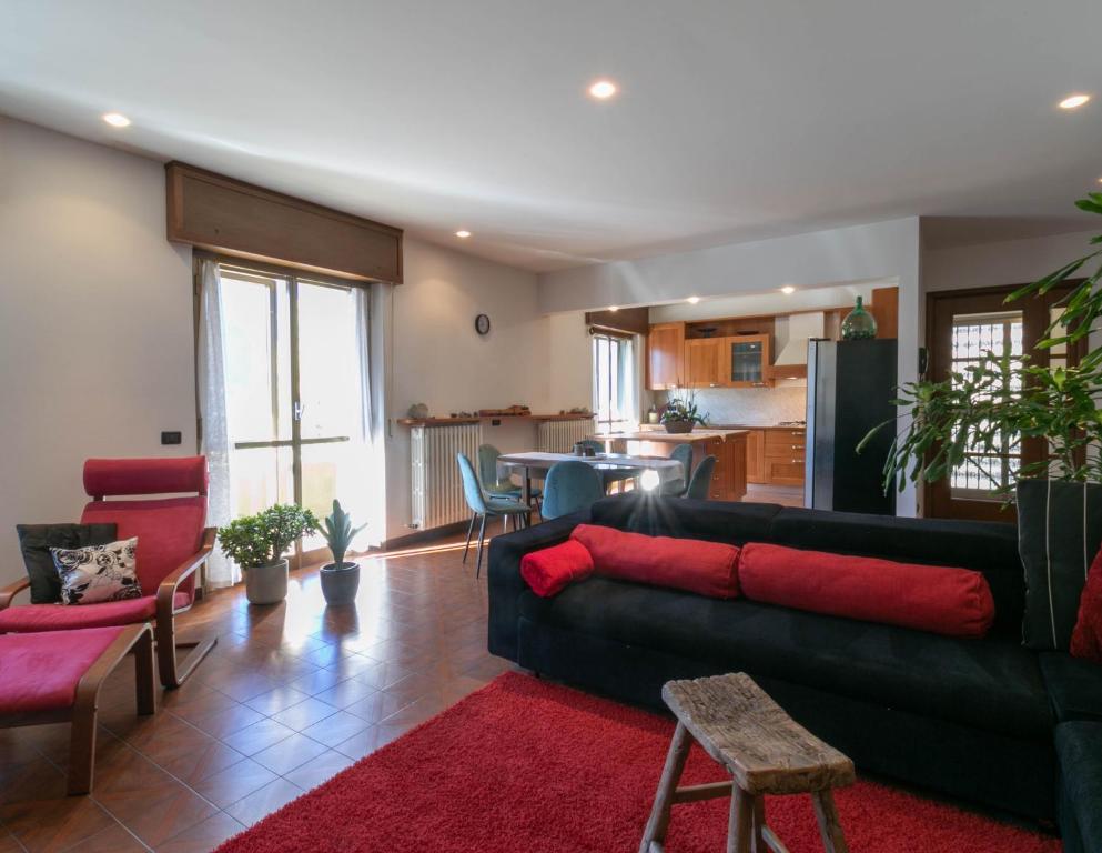 a living room with a black couch and a red rug at La Soliva Big House in Primaluna
