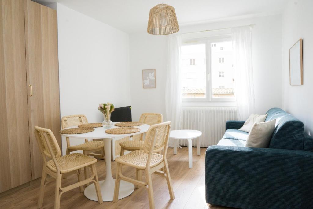 ein Wohnzimmer mit einem Tisch, Stühlen und einem Sofa in der Unterkunft Beautiful 2 Bedroom apartment in a quiet residence in Garches