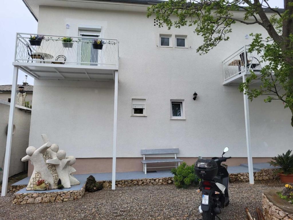 einem Roller, der vor einem weißen Gebäude parkt in der Unterkunft Rooms with a parking space Novi Vinodolski - 21509 in Novi Vinodolski