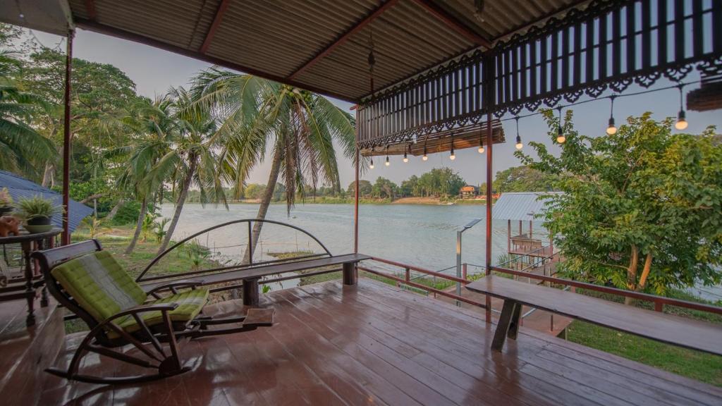 porche con banco y vistas al agua en River Flow House (บ้านสายนํ้า), en Ratchaburi