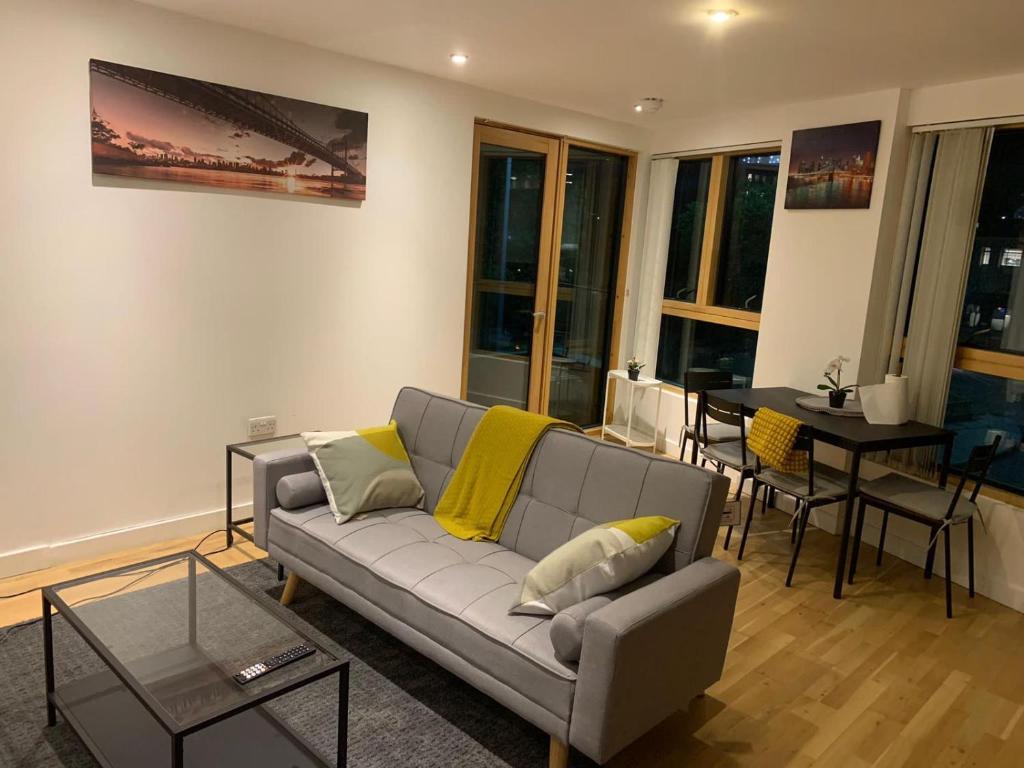 ein Wohnzimmer mit einem Sofa und einem Tisch in der Unterkunft Luxury Flat Town Centre in Reading
