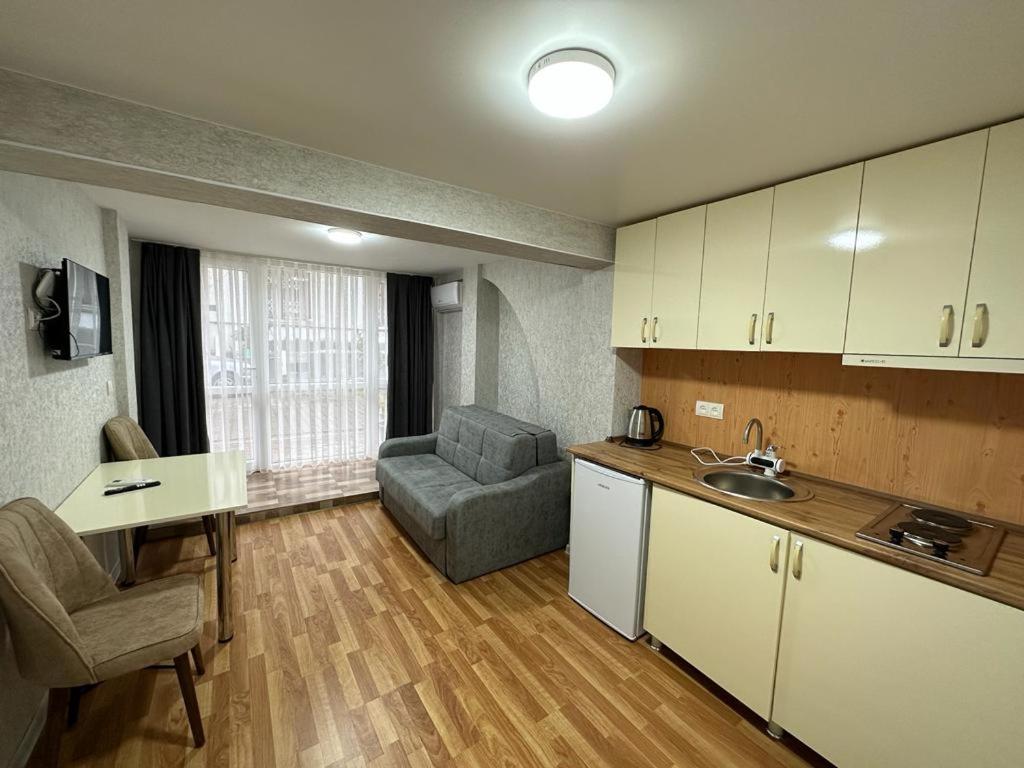 een keuken en een woonkamer met een bank en een tafel bij Hotel Old Boulvared in Batoemi