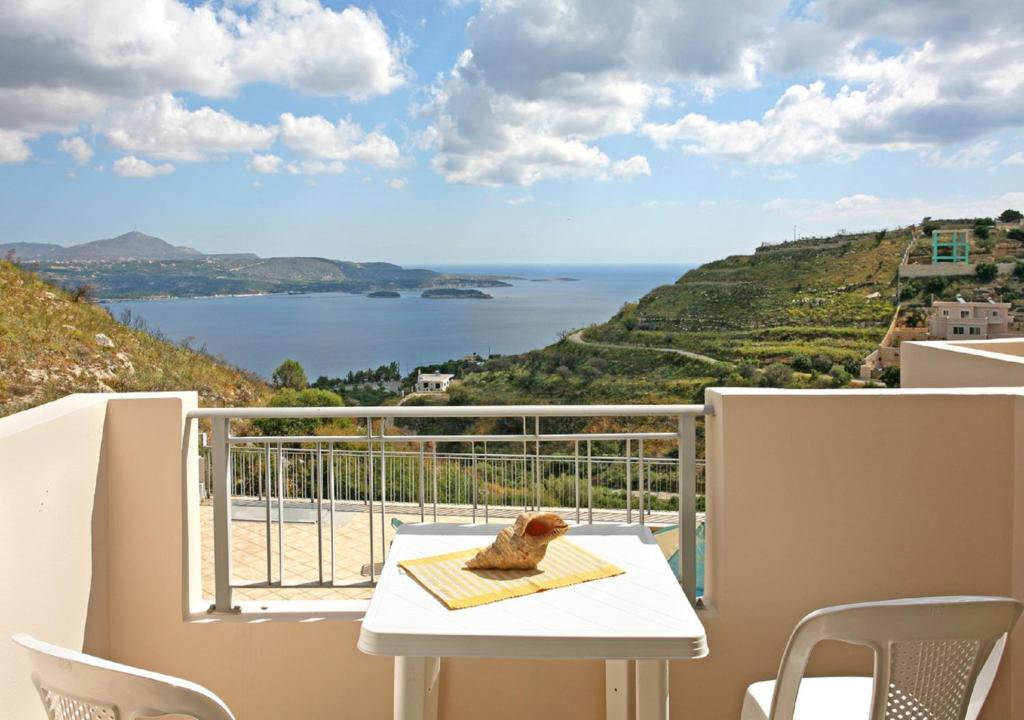 a balcony with a table and a view of the ocean at Aptera Paradise With Sea View in Megála Khoráfia