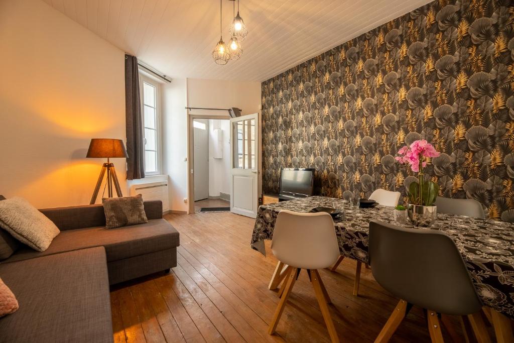 una sala de estar con una mesa y un sofá en La Perle de Cognac, en Cognac