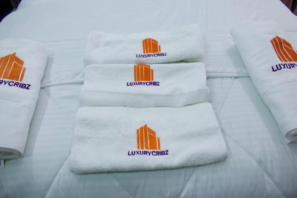 um grupo de toalhas brancas numa cama em The Hidden Gem Wuye em Abuja