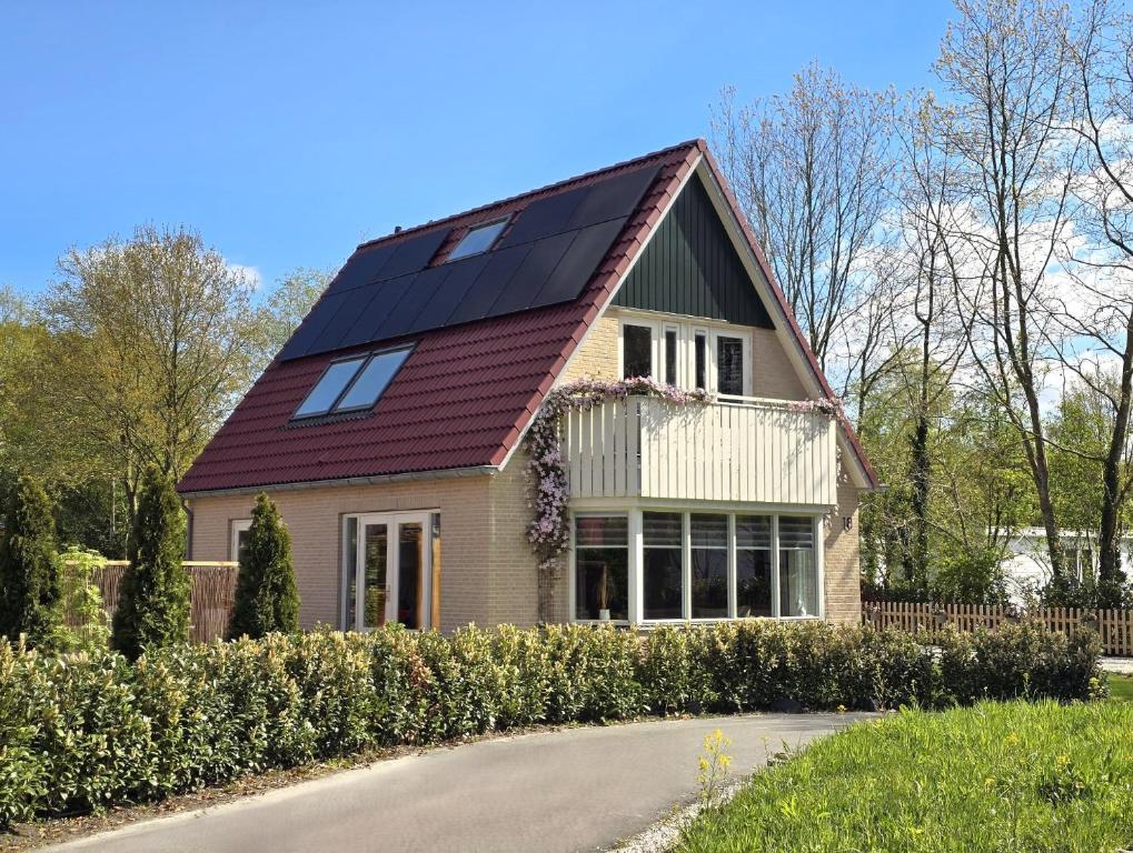 ein Haus mit Sonnenkollektoren auf dem Dach in der Unterkunft Natuurvilla De Heerlickheyt in Hoogersmilde