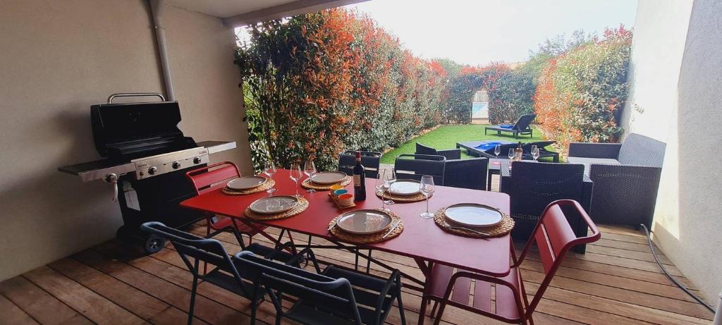 a patio with a table and chairs and a grill at Mini villa Bay, 6 pers, piscine, 400 m plage in Lecci