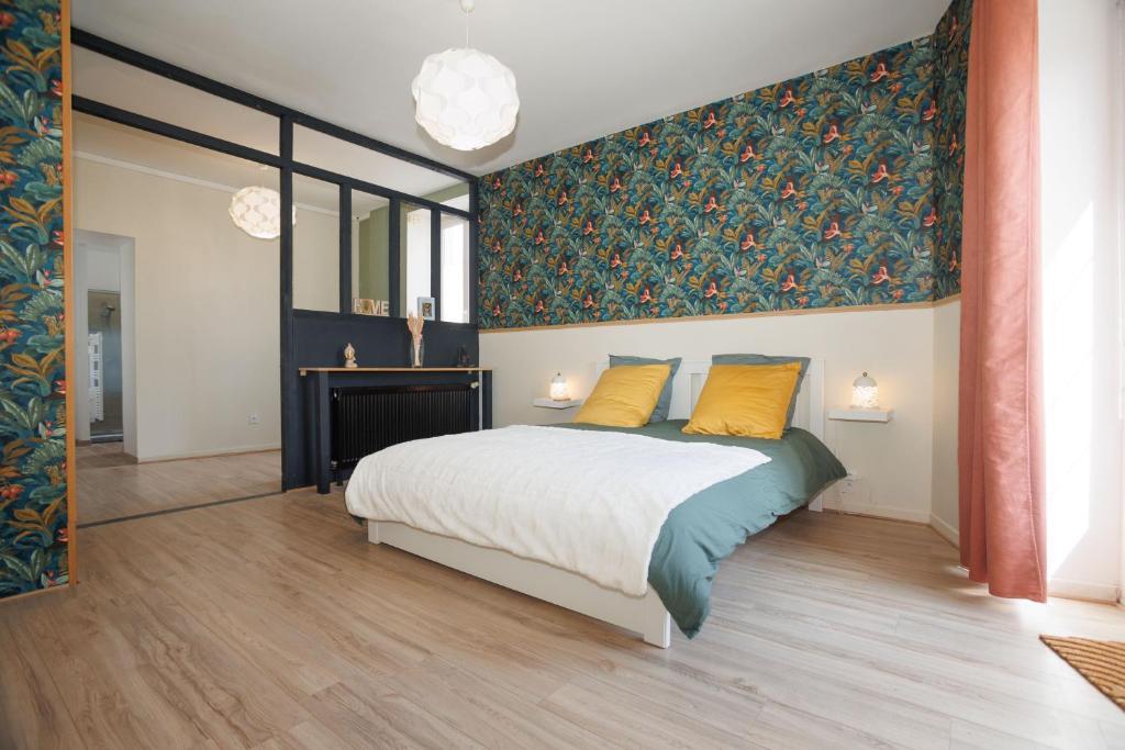 um quarto com uma cama grande e almofadas amarelas em Maison du Bien-être em Yvré-le-Pôlin
