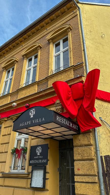 a building with a red bow on the side of it at Agape Villa Boutique Hotel in Novi Sad
