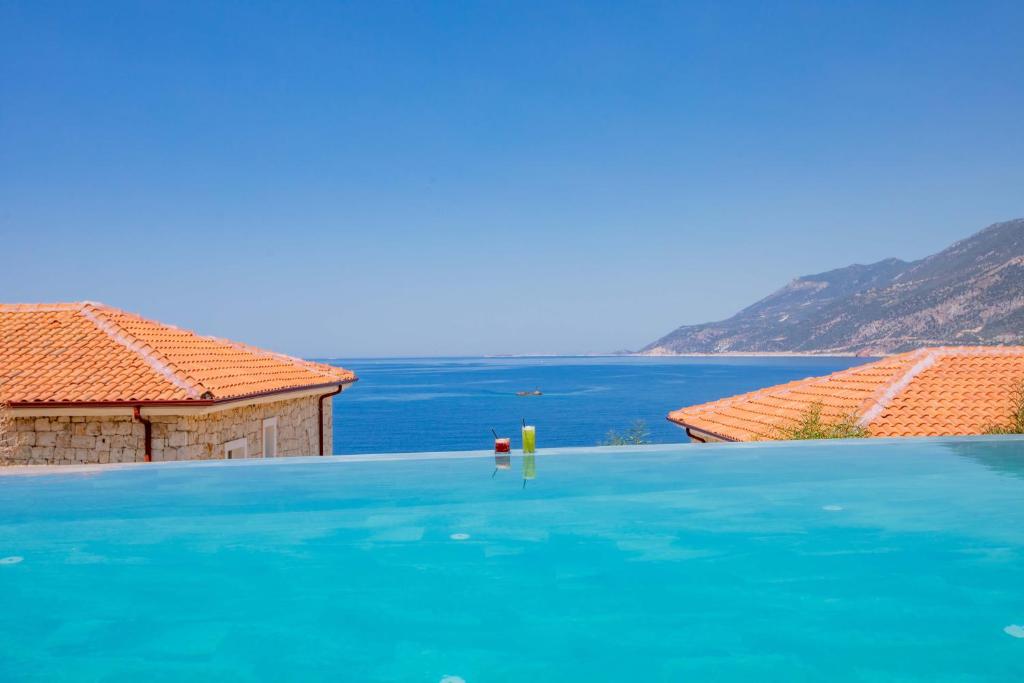 a swimming pool with a view of the water at Mavilim Hotel in Kaş