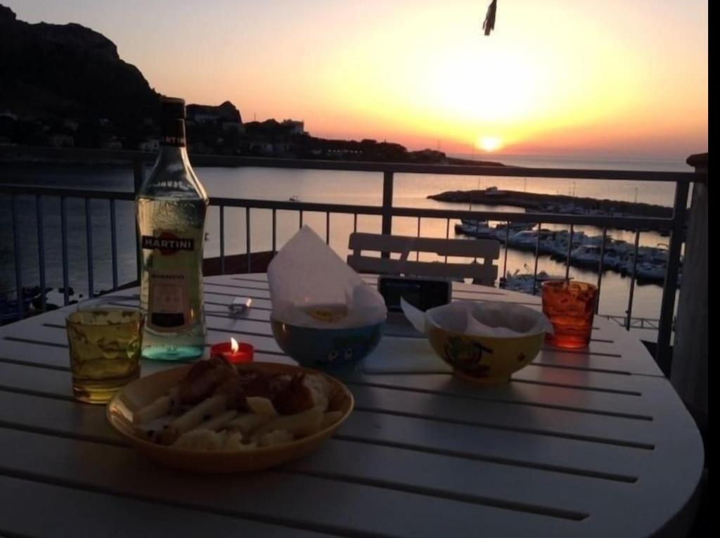 una mesa con una botella de vino y tazones de comida en Scalo17, en Palermo