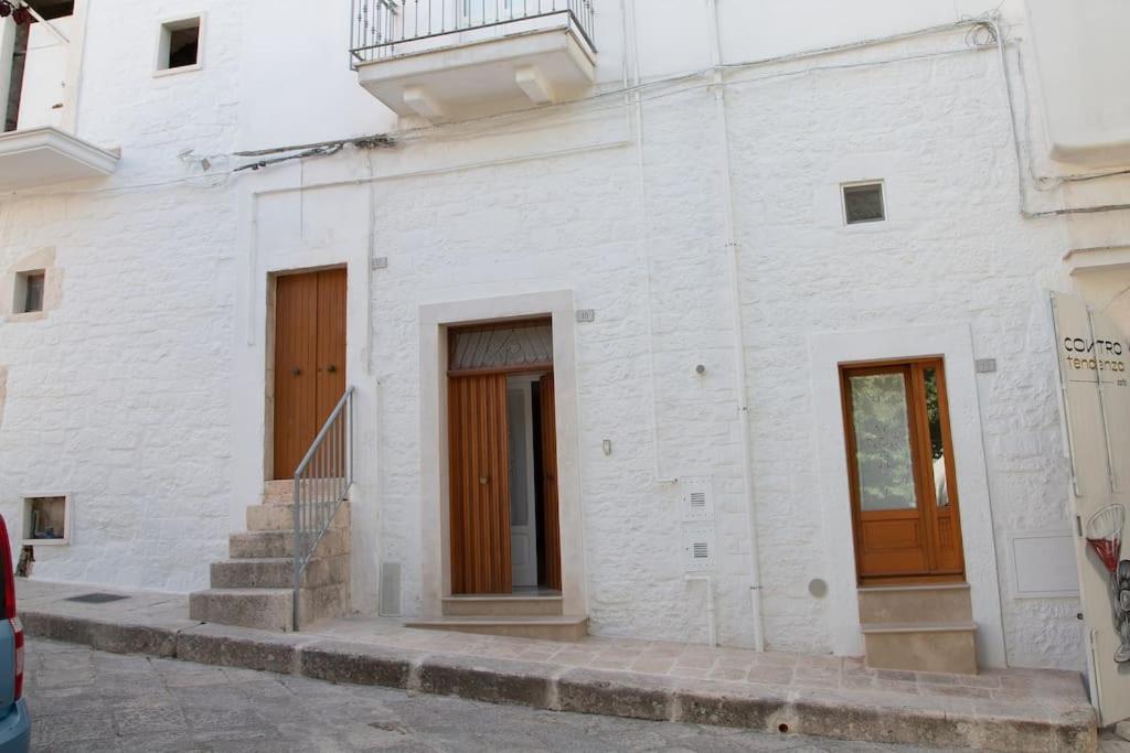 ein weißes Gebäude mit zwei Türen und Treppen darauf in der Unterkunft Cummersa Mazzini casa tipica nel Centro storico DI Locorotondo in Locorotondo