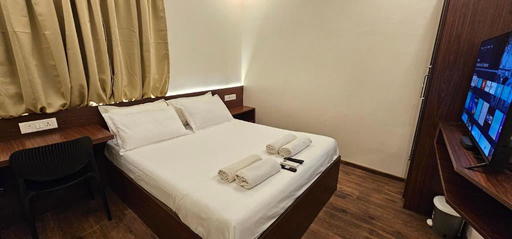 a hotel room with a bed with towels on it at Chippy Inn in Chennai