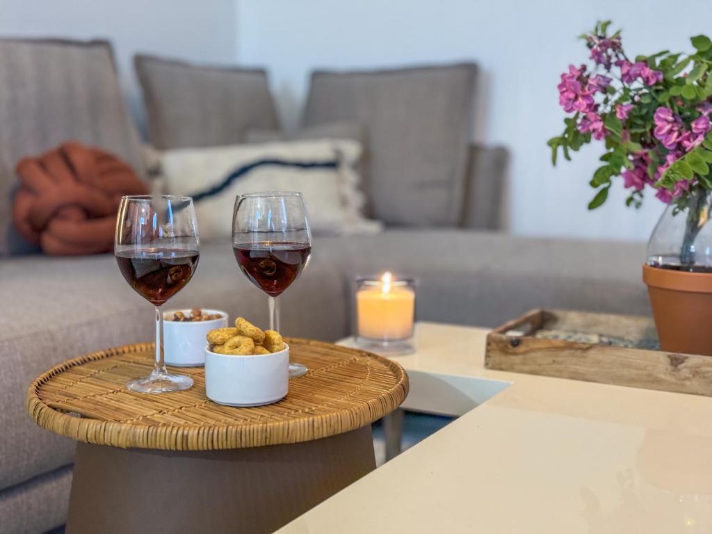 two glasses of wine and a bowl of food on a table at Le BLUET * entièrement équipe * tout confort in Grenade-sur-Garonne