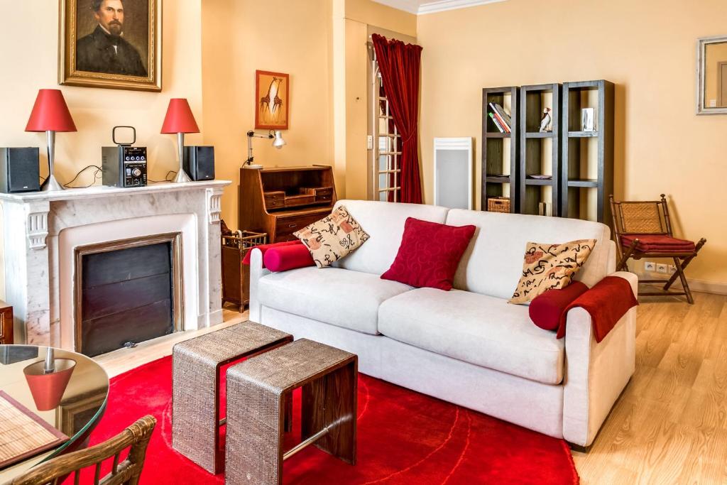 un salon avec un canapé blanc et une cheminée dans l'établissement Studio Montorgueil - Welkeys, à Paris