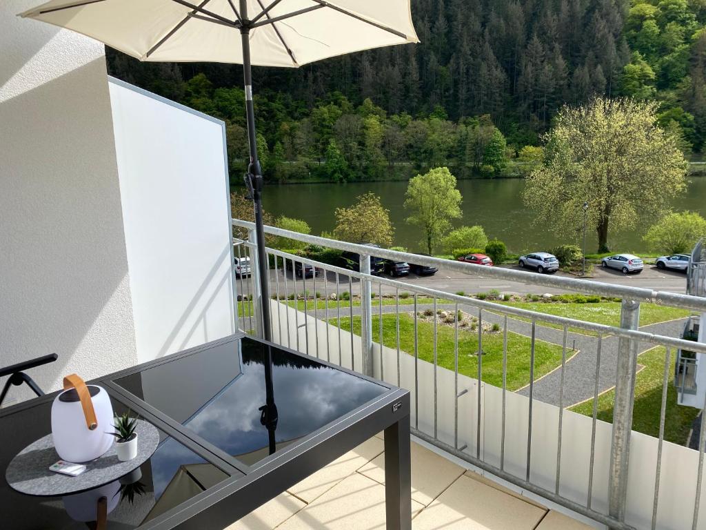 balcone con ombrellone e vista sul fiume di Neu!!! Ferienwohnung Mosel 106,5 a Traben-Trarbach