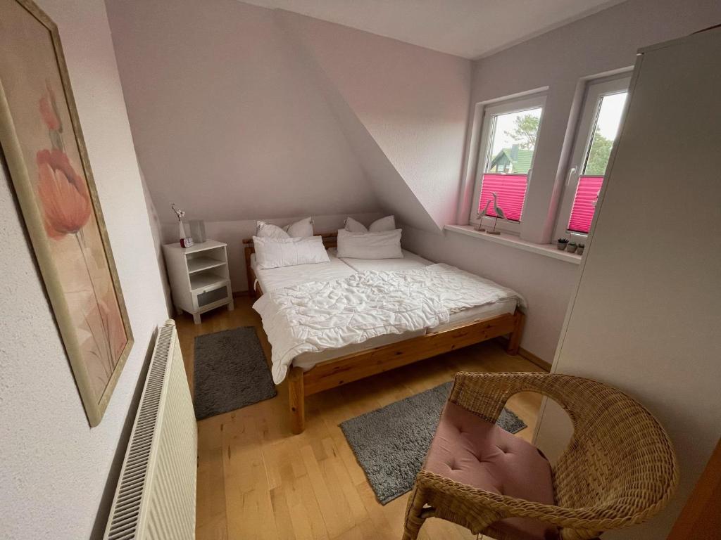 um pequeno quarto com uma cama e 2 janelas em Ferienwohnung Diana em Fuhlendorf