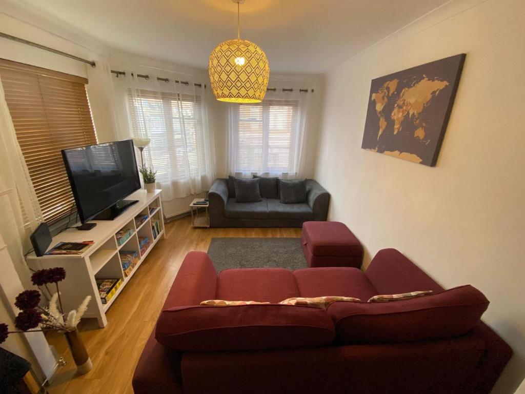 a living room with a couch and a flat screen tv at Beautiful 3-Bed Apartment in Hythe High Street in Hythe