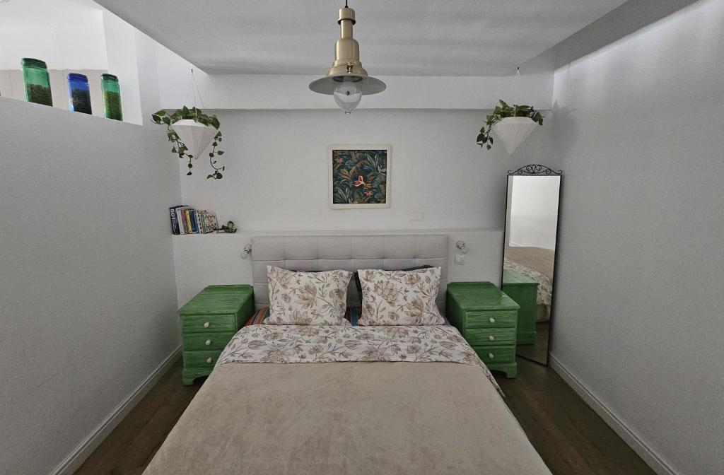 Unique Sea & City Lifestyle Studio في ليماسول: غرفة نوم صغيرة بها سرير وغرفتين خضراء