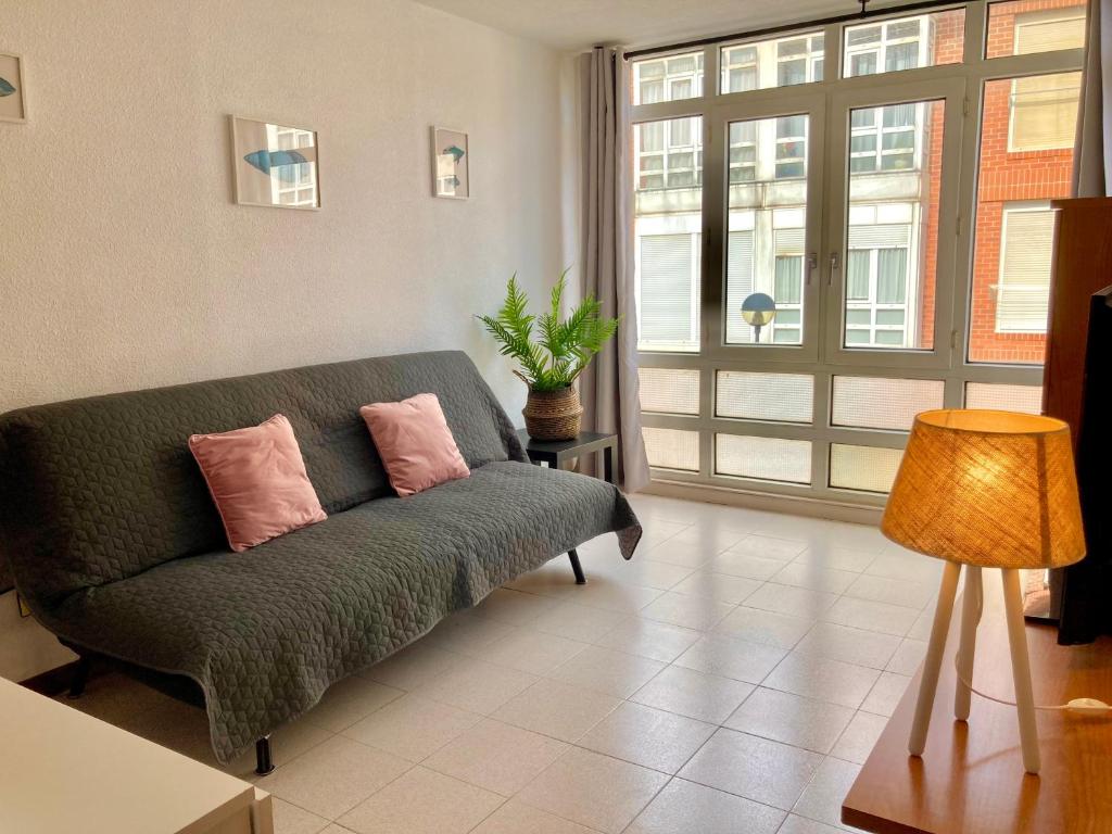 Una sala de estar con un sofá y una ventana grande. en Apartamento SomoMar, en Somo