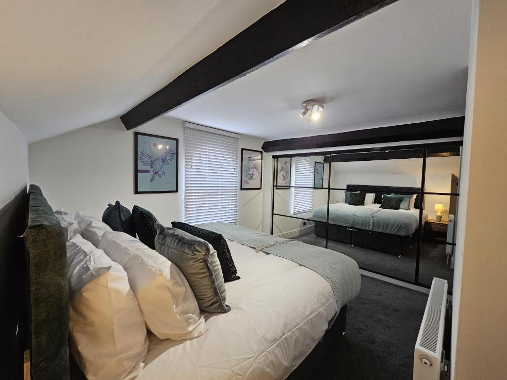a bedroom with a large bed and a mirror at Oxton Apartments - JCS Property 10 minutes from Central Liverpool in Upton