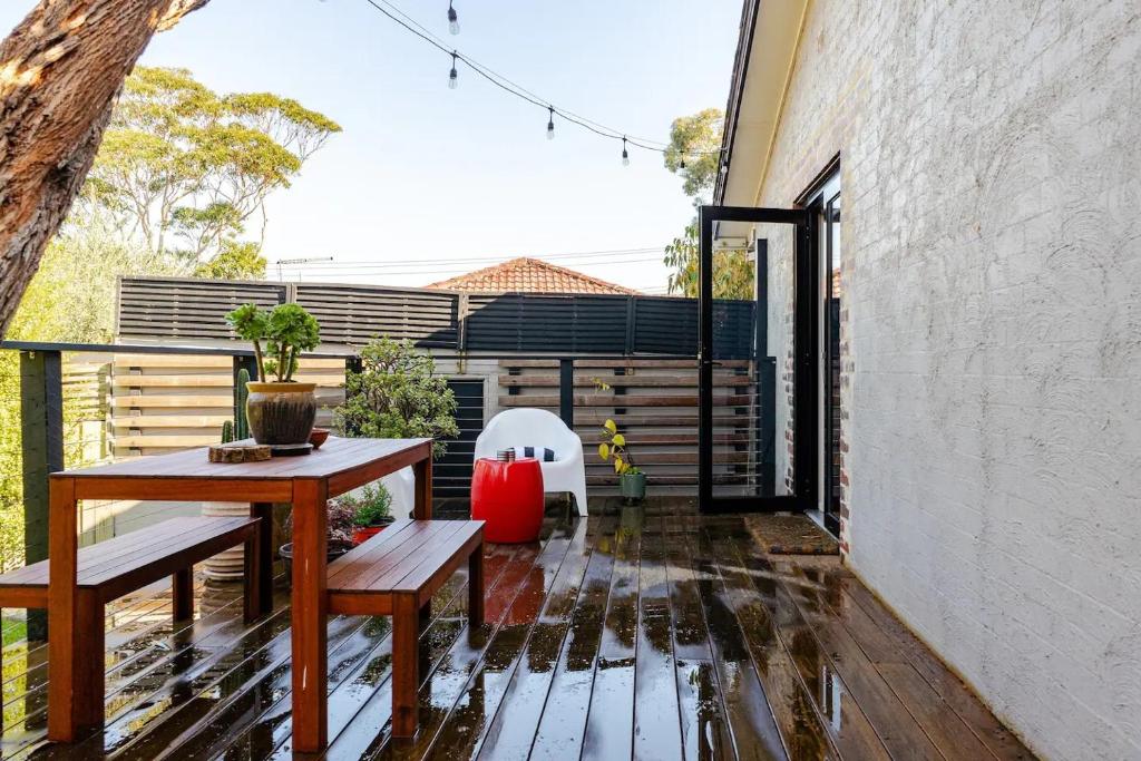 a patio with a table and benches on a balcony at Frankston South Beachside Gem in Frankston South