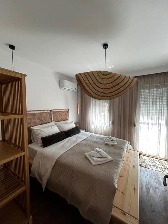 a bedroom with a large bed with two towels on it at Homefeel2024 in Kavala