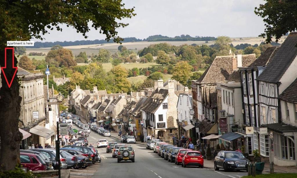 a busy street in a small town with cars parked at Davenford Burford in Burford