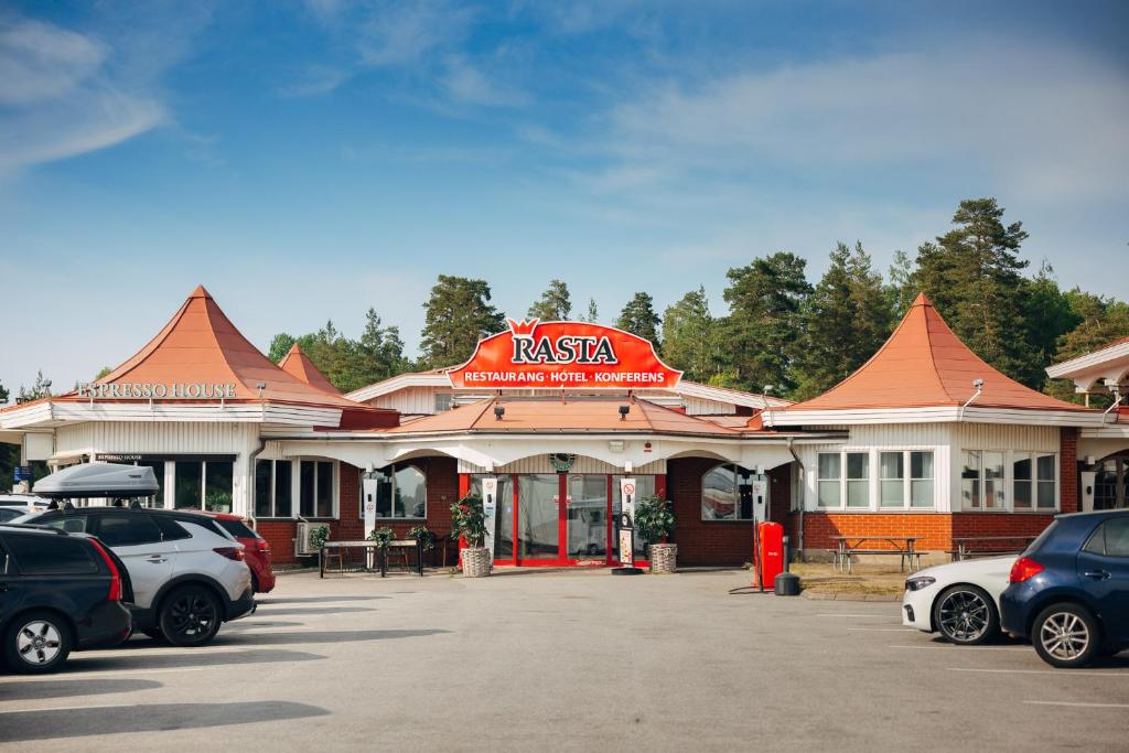 a restaurant with cars parked in a parking lot at Rasta Mariestad in Mariestad