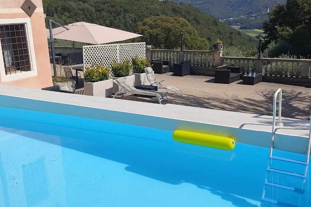 a blue swimming pool with a yellow object in front of a house at Locanda degli Ulivi in Arcugnano