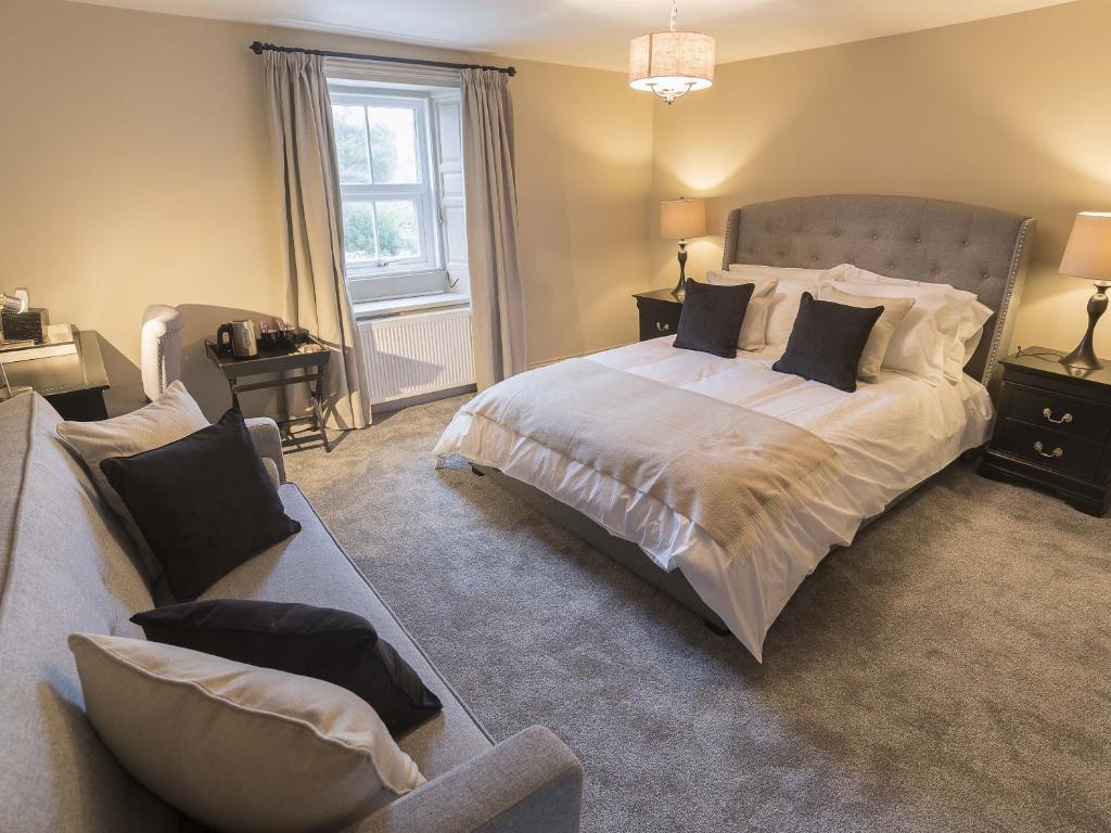 a bedroom with a large bed and a couch at New Crown Inn in Appleby