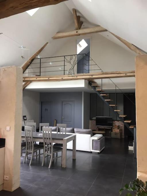 a dining room with a table and chairs and a staircase at Le Breuil in Amboise