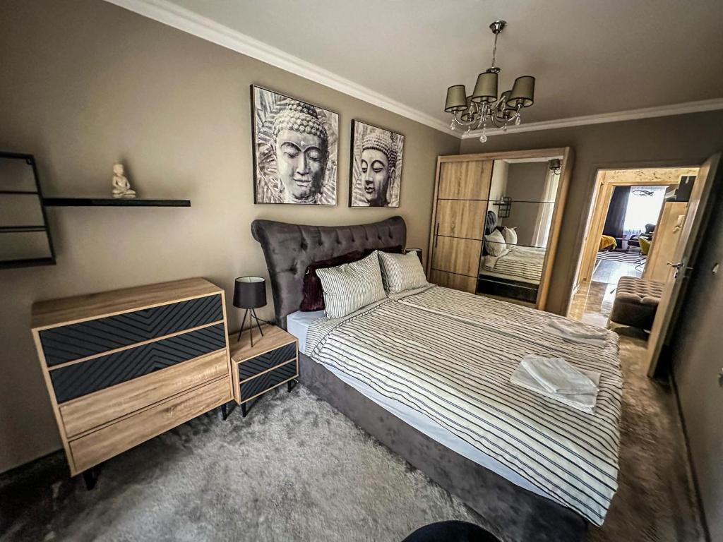a bedroom with a bed and two pictures on the wall at APARTMENT ROYAL ASENOVGRAD in Asenovgrad