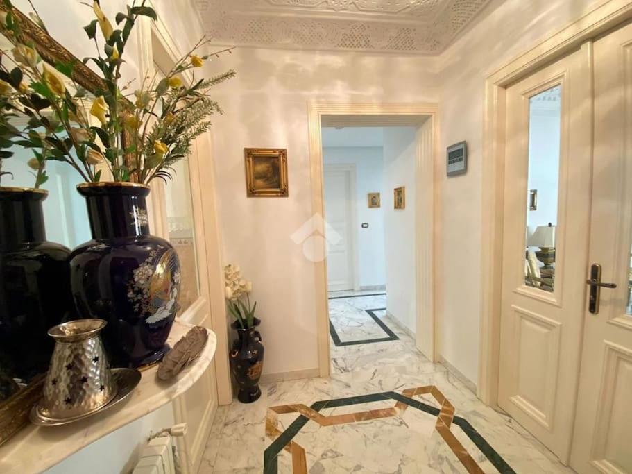 a hallway with a vase on a counter and a door at The Epitome of Luxury: S+2 Apart & Parking Ennasr2 in Ariana