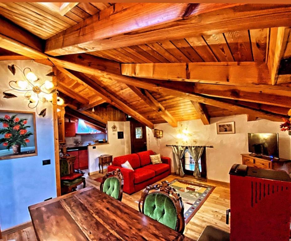 uma sala de estar com um sofá vermelho e uma mesa em La Maison de Julie em Pré-Saint-Didier