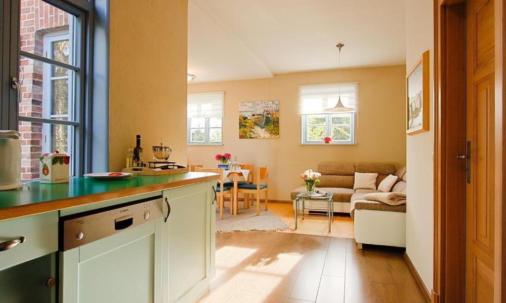 uma cozinha com um balcão e uma sala de estar em Haus zu den Büschen 02 em Wustrow